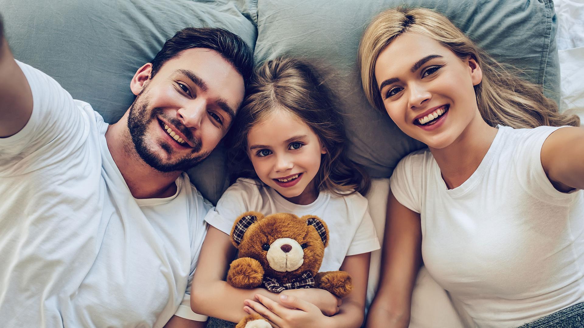 Camera moderna con letto matrimoniale, pavimento in legno, TV e scrivania.